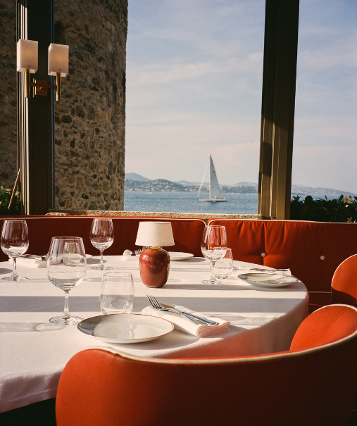 Salle du restaurant plage Pampelonne sous pergola bois, chaises rotin et tables dressées